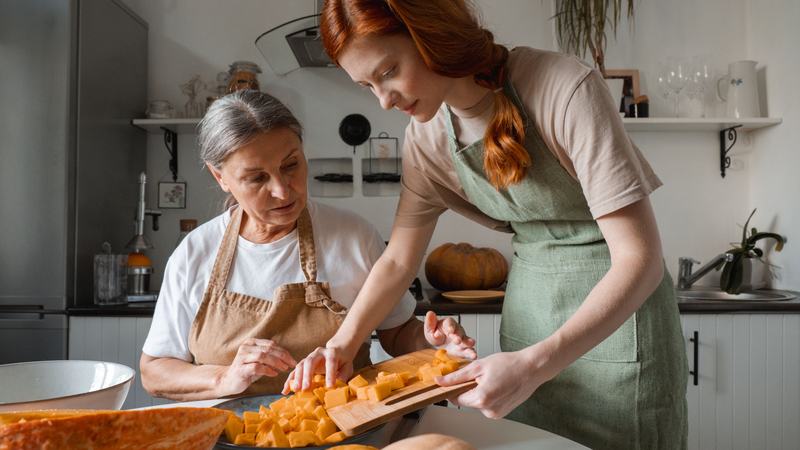 A photo of a daughter making soup with her elderly mother